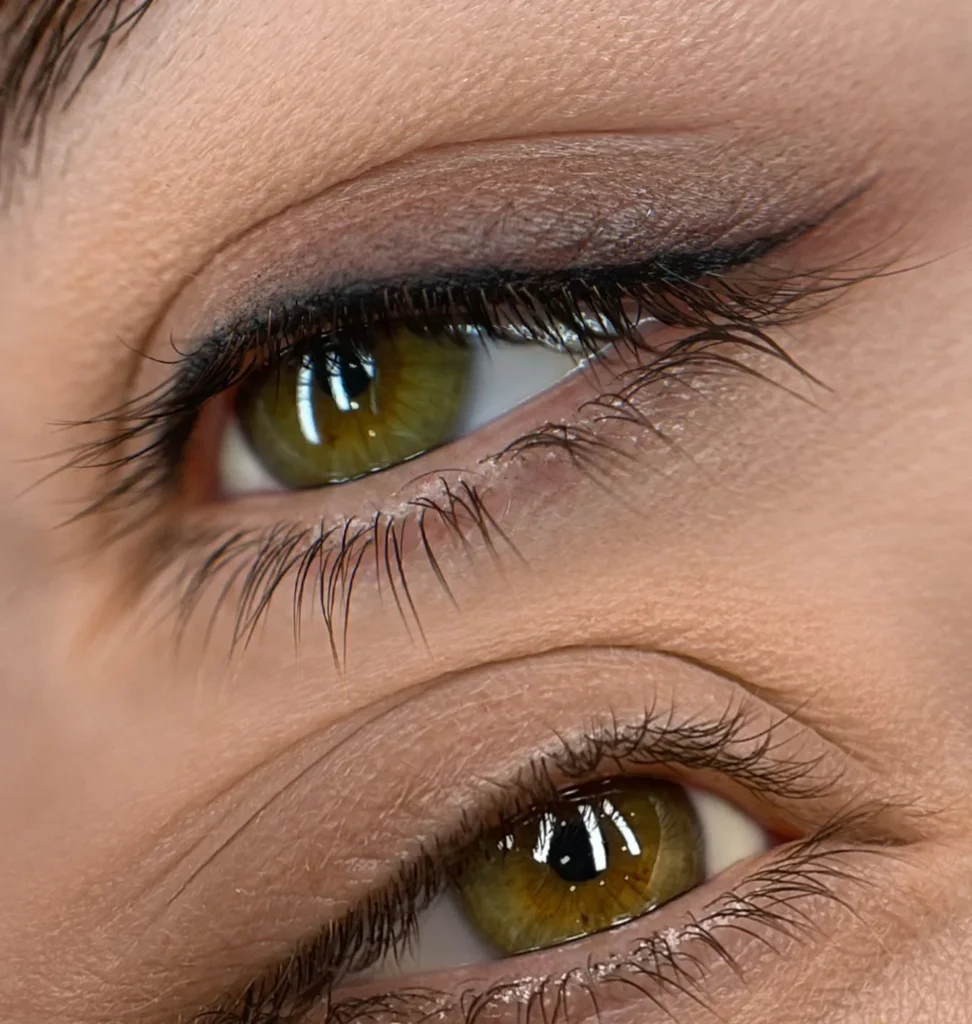 Close-up of green eyes with a fine permanent eyeliner along the lash line